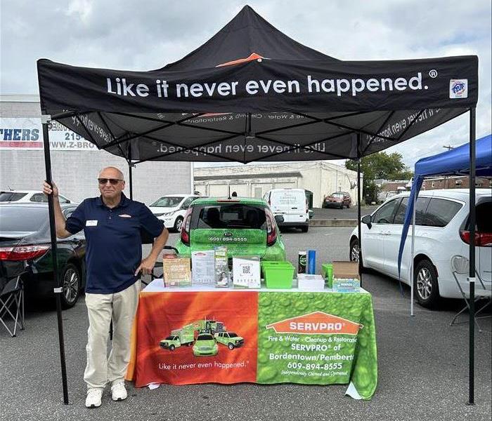 man standing next to company tent